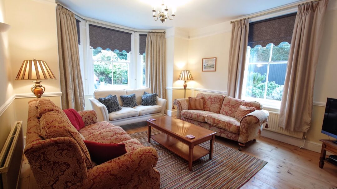Living Room North Cottage Cromer with three comfy sofas, smart Sony TV and log burner.