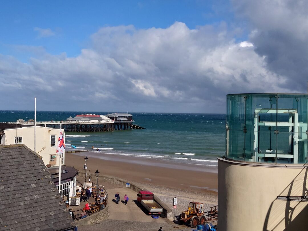View of Cromer beach showing Cromer Pier and the Rocket House lift to the promenade.